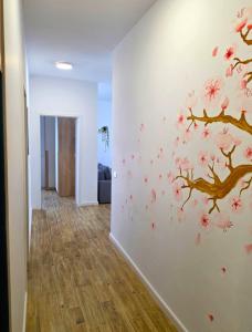 a hallway with a wall with pink flowers on it at Sakura Residence Felix in Sînmartin