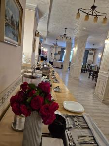 a lobby with a long table with flowers in a room at Hotel Royal Craiova in Craiova