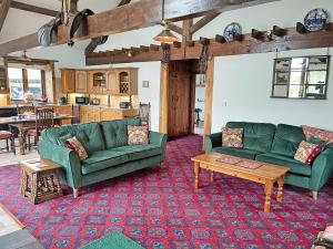 a living room with two green couches and a table at The Barton in Launceston