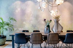 a dining room with a table with chairs and vases at Motel One Amsterdam in Amsterdam