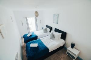 a bedroom with two beds with blue sheets at The Graigfryn Hideaway in Amlwch