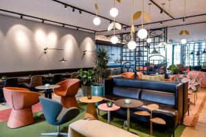 a lobby with tables and chairs and a couch at Motel One Amsterdam in Amsterdam