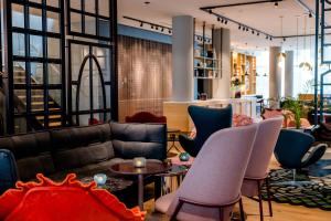 a living room with a couch and chairs at Motel One Amsterdam in Amsterdam