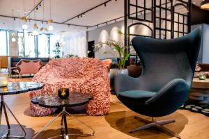 a living room with a chair and a table at Motel One Amsterdam in Amsterdam