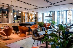a restaurant with tables and chairs and plants at Motel One Amsterdam in Amsterdam +76 photos