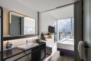 a bathroom with a sink and a mirror at YOTEL Bangkok Sukhumvit in Ban Nong Chaeng