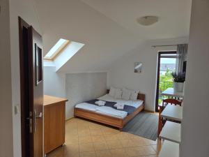 a bedroom with a bed and a table and a window at Malinowe Lato in Grzybowo