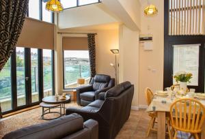 a living room with a couch and chairs and a table at Ger Y Llanw Aberaeron in Aberaeron