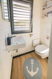 a bathroom with a sink and a toilet and a rug at Floatinghouse Nike in Hennigsdorf