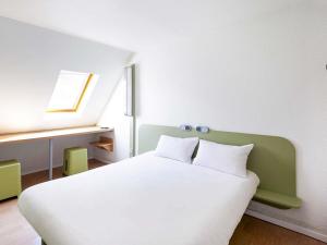 a white bed with two pillows in a room at ibis budget Blois Centre in Blois