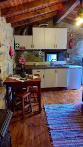 a kitchen with a table and a sink and a counter at Refúgio do Casal in Lousã