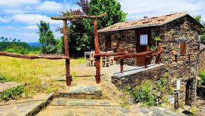 a small stone building in a field at Refúgio do Casal in Lousã