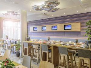 a restaurant with a long table and chairs at Novotel München City Arnulfpark in Munich