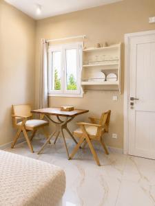 a dining room with a table and chairs and a window at Pelekouda Coastal Apartments in Pollonia