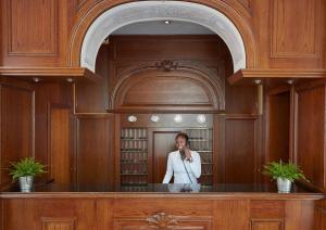 a woman talking on a cell phone in front of a mirror at Living Hotel Berlin Mitte in Berlin