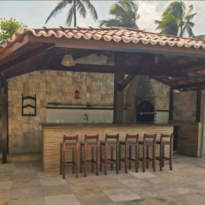 a group of chairs sitting under an outdoor kitchen at Ventos e Dunas Cumbuco in Cumbuco