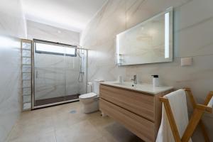a bathroom with a toilet and a sink and a shower at Casa Turalves - By WeHostMadeira in Porto Santo +26 photos