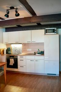 a kitchen with white cabinets and a sink at PrimeBnb Bad Hersfeld in Bad Hersfeld