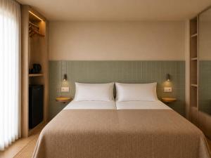 a bedroom with a large bed with two pillows at Colectia Hotel Santa Lucía in Seville