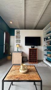 a living room with a coffee table and a tv at MATANAI HOUSE X THHP - The Deck Villa Mukteshwar - 2 Bedroom Bonfire & BBQ in Mukteshwar