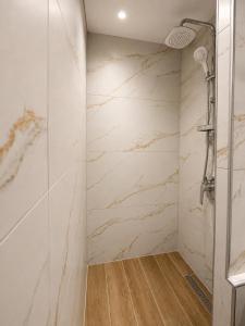 a bathroom with white marble walls and a shower at Pelekouda Coastal Apartments in Pollonia +20 photos