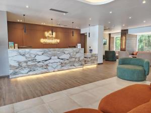 a lobby of a hospital with a stone counter at Hotel Margarita Dynasty in Porlamar