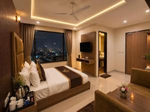 a hotel room with a bed and a large window at Hotel Bellwood Inn Near IGI Delhi International Airport in New Delhi