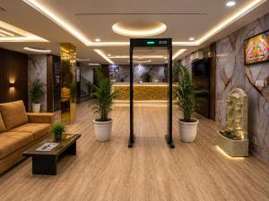 a lobby with a couch and potted plants at Hotel Bellwood Inn Near IGI Delhi International Airport in New Delhi