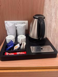 a tea kettle on a tray on a desk at Hotel Bellwood Inn Near IGI Delhi International Airport in New Delhi +16 photos