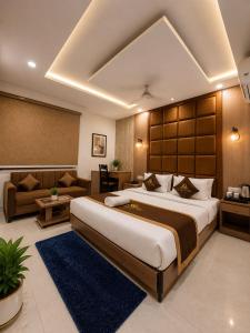 a large bedroom with a large bed and a couch at Hotel Bellwood Inn Near IGI Delhi International Airport in New Delhi