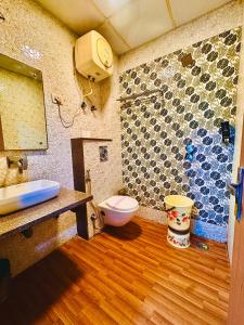 a bathroom with a toilet and a stone wall at Hotel Bellwood Inn Near IGI Delhi International Airport in New Delhi
