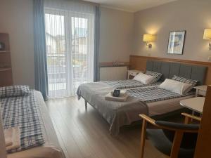 a hotel room with two beds and a window at Pensjonat Nautilus in Karwia