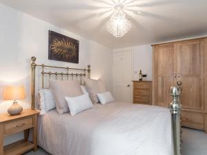 a bedroom with a bed and a chandelier at One Beckside Cottage in Staithes +7 photos