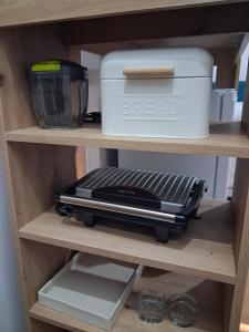 a shelf with a toaster and a container on it at Sunshine- self sheck in in Čačak