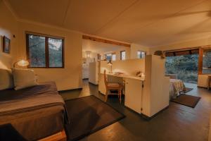 a bedroom with a bed and a desk in a room at Leshiba Wilderness in Louis Trichardt