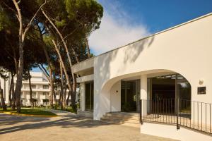 an external view of a white building with trees at SOL by Meliá Tropikal Durres in Durrës