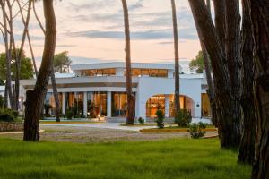 a white house with trees in front of it at SOL by Meliá Tropikal Durres in Durrës +105 photos