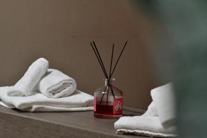 a bathroom counter with towels and a vase with sticks at Gran Paradiso Guest House in Tivoli