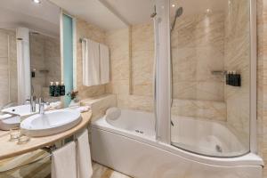 a bathroom with a tub and a sink at Meliá Athens in Athens