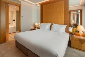 a bedroom with a large white bed and a bathroom at Meliá Athens in Athens