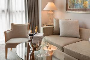 a living room with a couch and a glass table at Meliá Athens in Athens