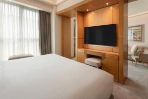 a hotel room with a bed and a flat screen tv at Meliá Athens in Athens
