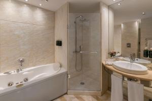 a bathroom with a tub and a sink and a shower at Meliá Athens in Athens +85 photos