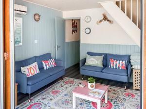 a living room with two blue couches and a table at Lodge 64 in Kingsdown
