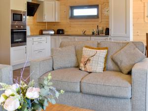 a couch with a dog pillow on it in a kitchen at Oak Lodge - Uk30005 in Lindal in Furness