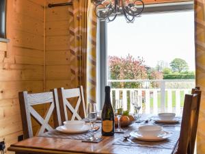 a dining room table with a bottle of wine at Oak Lodge - Uk30005 in Lindal in Furness