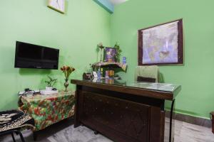 a room with a desk and a tv on the wall at Hotel O Suvidha in Jamshedpur