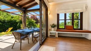 a dining room with a blue table and some windows at Villa Costa Cue in Cue