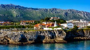 a town on a cliff next to the water at Villa Costa Cue in Cue