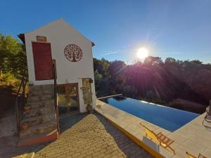 a villa with a swimming pool in front of a house at Lugar dos Meandros 